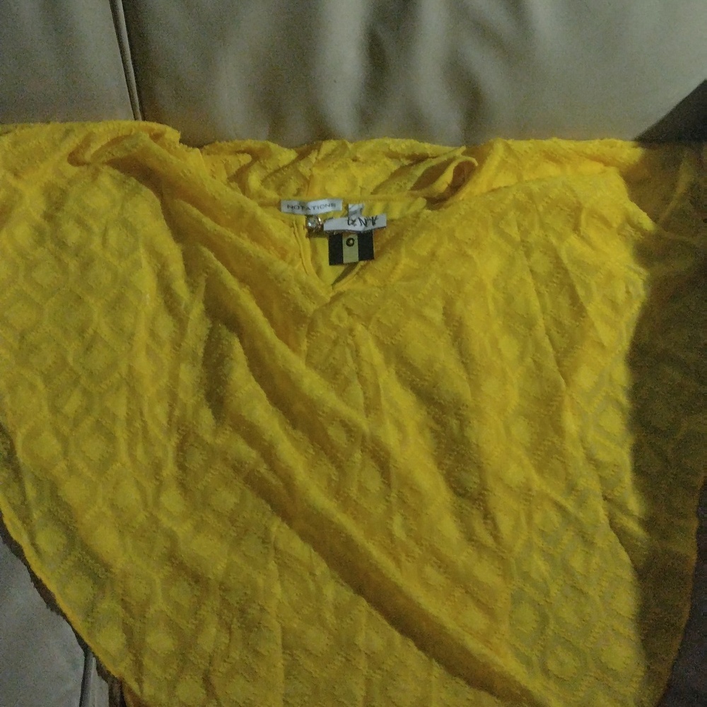 Yello see through shirt with gold clasp at throat.